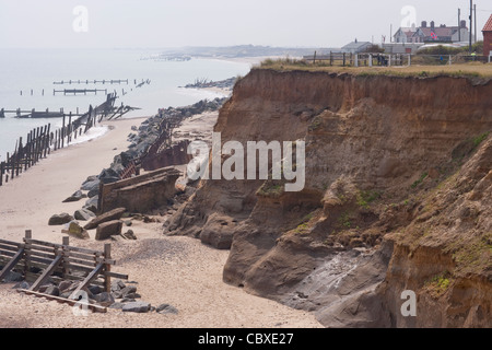 Happisburgh litorale nord di Norfolk, East Anglia. Erosione delle scogliere dal Mare del Nord ; case, avanti per andare. Rocce importate al di sotto di Foto Stock