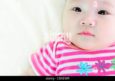 Curioso di 5 mesi di età bambino asiatico cercando Foto Stock