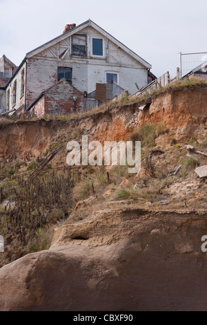 Happisburgh litorale nord di Norfolk, East Anglia. Erosione delle scogliere dal Mare del Nord ; case e ville sulla scogliera edge, avanti per andare. Foto Stock