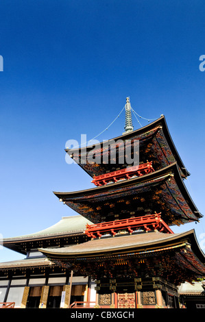 Tempio Naritasan Shinshoji Pagoda a tre piani Narita Giappone // NARITA, Giappone - travi ornati della Pagoda a tre piani del tempio Naritasan Shinshoji mostrano colori vibranti e intricati disegni caratteristici della tradizionale architettura buddista giapponese. La pagoda alta 25 metri è stata originariamente costruita nel 1712 e rappresenta una delle strutture più significative del tempio. Il tempio Naritasan Shinshoji, fondato nel 940, è dedicato a Fudo Myoo e funge da tempio principale del ramo Chisan della setta buddista Shingon. Il complesso del tempio attrae milioni di visitatori ogni anno, p Foto Stock