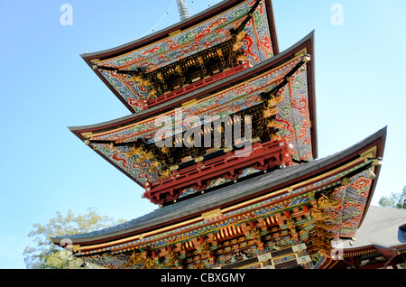 Tempio Naritasan Shinshoji Pagoda a tre piani Narita Giappone // NARITA, Giappone - travi ornati della Pagoda a tre piani del tempio Naritasan Shinshoji mostrano colori vibranti e intricati disegni caratteristici della tradizionale architettura buddista giapponese. La pagoda alta 25 metri è stata originariamente costruita nel 1712 e rappresenta una delle strutture più significative del tempio. Il tempio Naritasan Shinshoji, fondato nel 940, è dedicato a Fudo Myoo e funge da tempio principale del ramo Chisan della setta buddista Shingon. Il complesso del tempio attrae milioni di visitatori ogni anno, p Foto Stock