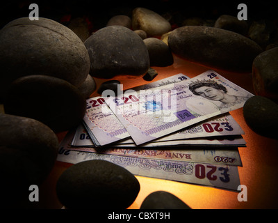 Venti pound note accanto a pietre Foto Stock