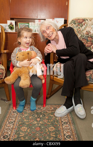 Grande nonna e grandioso grand figlia seduti insieme divertendosi Foto Stock