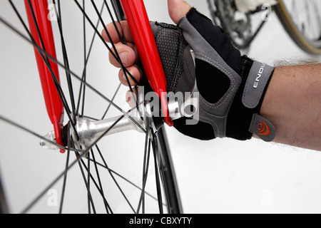 L'uomo facendo di meccanismo di rilascio rapido sulla bici da corsa Foto Stock