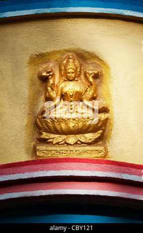 Oro dipinta divinità Indù statua su una parete. Andhra Pradesh, India Foto Stock