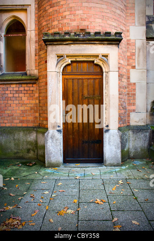 Chiesa di legno porta con pietra surround e un muro di mattoni Foto Stock