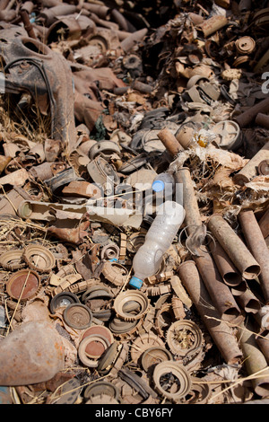 Parti di mine antiuomo e di artiglieria e di mortaio giacciono arrugginimento al sole in un cantiere di scarto in Iraq. Foto Stock