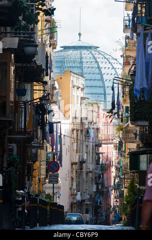 Una strada stretta a Napoli, Italia, con Galleria Umberto shopping arcade in distanza. Foto Stock