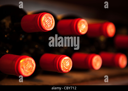 Abstract di vino rosso bottiglia tops su un rack di vino Foto Stock