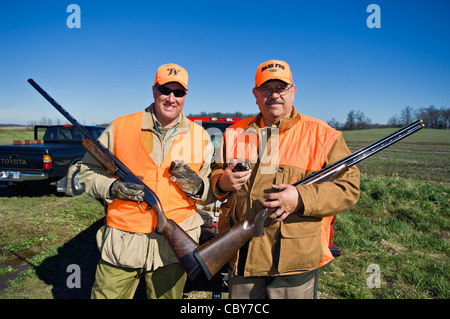 Due Upland Bird cacciatori in posa con fucili a canna liscia e Bobwhite Quaglia Foto Stock