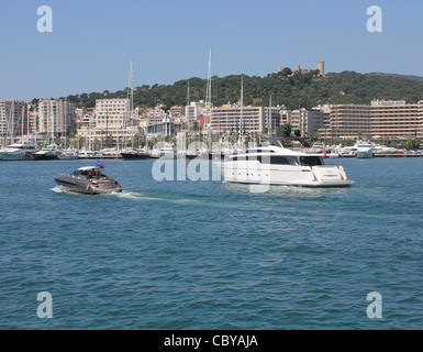 In scena il porto di Palma de Mallorca - lusso italiano Riva yacht a motore passando un Sanlorenzo SL104 superyacht di lusso Foto Stock