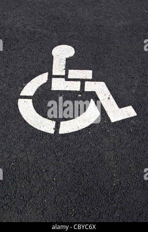 Un handicap bianco simbolo di parcheggio è dipinta su una pavimentazione di nero. Foto Stock