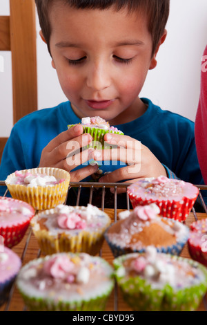 Giovane ragazzo tortini di mangiare da soli. Foto Stock