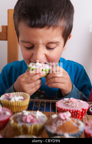 Giovane ragazzo tortini di mangiare da soli. Foto Stock