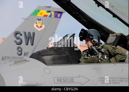 Greg Farrell si stringe nel suo F-16 Fighting Falcon prima di una missione di addestramento alla bandiera rossa il 23 febbraio 2010, alla base dell'aeronautica di Nellis, Never. Red Flag è un esercizio di addestramento realistico di combattimento che coinvolge le forze aeree degli Stati Uniti e dei suoi alleati. Il tenente Farrell è un pilota del 55° Squadrone dei combattenti presso Shaw AFB, S.C. Foto Stock