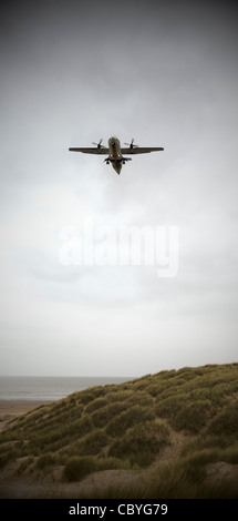 Aeromobile proveniente in terra oltre il mare e le dune di sabbia su un tetro inverni di giorno Foto Stock