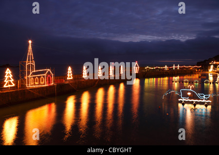 Mousehole le luci di Natale, inverno luminarie riflessa nell'acqua di notte, [Mousehole harbour], Cornwall, Regno Unito Foto Stock