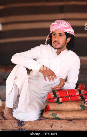 Giovane beduino, le popolazioni nomadi arabe, in casa sua tenda nel deserto di Wadi Rum, Giordania Foto Stock