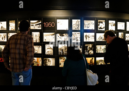 WASHINGTON DC, Stati Uniti: I visitatori esaminano la collezione completa di fotografie vincitrici del Premio Pulitzer presso la galleria Newseum. Lo spazio espositivo consente agli spettatori di studiare immagini che catturano momenti cruciali della storia. Gli ospiti del museo leggono le didascalie dettagliate che spiegano il contesto e il significato di ogni fotografia. Il Newseum chiuse nel 2019. Foto Stock