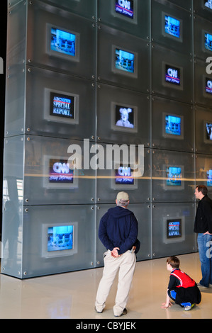 WASHINGTON DC, Stati Uniti - i visitatori osservano il muro di schermi televisivi del Newseum che mostra più trasmissioni di notizie contemporaneamente. La mostra mostra mostra come diverse reti coprono eventi di attualità. Il display mostra l'evoluzione del giornalismo televisivo e della copertura di notizie nell'era moderna. Il Newseum chiuse nel 2019. Foto Stock