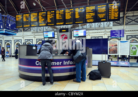 Treno passeggeri assistenza presso il cliente Informazioni service desk presso la stazione di Paddington (personale faccia oscurata) Londra Inghilterra REGNO UNITO Foto Stock