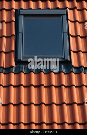 Dormer su un tetto di tegole rosse e Foto Stock