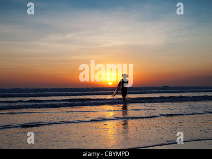 Surfer e onde al tramonto a Bali, in Indonesia Foto Stock