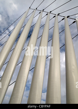 Metallico ponte colonnare supporta cavi con torre al di sopra di Salford Quays contro un cielo blu con cloud rotto Foto Stock