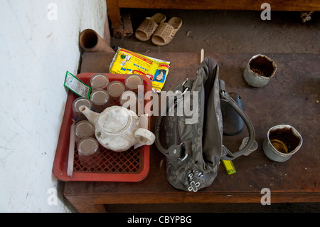 Le donne la borsa sul tavolo con tazze tè nella povera famiglia vietnamita (Vietnam) Foto Stock