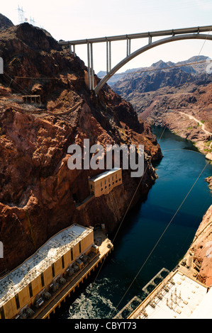 Diga di Hoover Mike O Callaghan Pat Tillman Memorial Bridge Las Vegas Nevada | DIGA DI HOOVER, Nevada — Il complesso idroelettrico della diga di Hoover si trova alla base della diga ad arco in cemento sul basso fiume Colorado, con due edifici di centrali elettriche che ospitano le turbine di generazione elettrica dell'impianto. La diga, completata nel 1936, fu costruita durante la Grande Depressione come parte del Boulder Canyon Project per controllare le inondazioni, fornire acqua di irrigazione e generare energia idroelettrica per il sud-ovest degli Stati Uniti. Sopra il complesso della diga, il ponte commemorativo Mike O'Callaghan – Pat Tillman sp Foto Stock