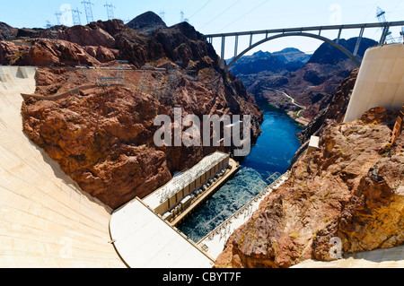 Diga di Hoover Mike o'Callaghan Pat Tillman Memorial Bridge fiume Colorado Arizona Nevada // DIGA DI HOOVER, confine Arizona-Nevada - l'enorme muro di cemento della diga di Hoover attraversa il fiume Colorado tra Arizona e Nevada, con gli edifici idroelettrici della turbina della diga visibili su entrambi i lati del fiume sottostante. Il Mike o'Callaghan - Pat Tillman Memorial Bridge attraversa il fiume Colorado a monte della diga, collegando i due stati. La diga di Hoover fu completata nel 1936 e si erge a 726 piedi di altezza, creando il lago Mead dietro la sua struttura ad arco-gravità in cemento. Il centro visitatori della diga si trova sulla Nevad Foto Stock