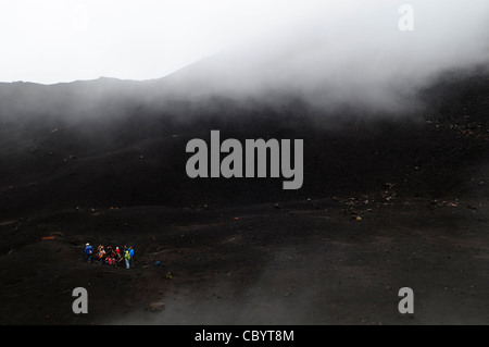 Escursionisti del vulcano Pacaya Guatemala // VULCANO PACAYA, Guatemala - Un gruppo di escursionisti in cima al vulcano Pacaya. Pacaya è un vulcano attivo che fa parte dell'arco vulcanico dell'America centrale. Costituisce una popolare destinazione turistica facilmente accessibile da Antigua e città del Guatemala. Situato all'interno del Parco Nazionale Pacaya, si erge a 2.552 metri (8.373 piedi). La sua ultima grande eruzione, che ha causato notevoli danni ai villaggi vicini e ha rimodellato la cima, è stata nel maggio 2010. Quell'eruzione e la cenere vulcanica sparsa su gran parte della zona circostante, provocando chiusure scolastiche e emergenza Foto Stock