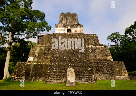 TIKAL, Guatemala - Tempio 2, noto anche come il Tempio delle Maschere, in Tikal rovine Maya nel nord del Guatemala, ora racchiusi nel Parco Nazionale di Tikal. In basso nella parte anteriore è una stela che una volta ha tenuto le iscrizioni commemorative che hanno in quanto usurato. Foto Stock