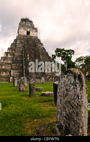 TIKAL, Guatemala - Tempio 1 (il Tempio del gigante Jaguar) con stelas nella piazza principale di Tikal rovine Maya nel nord del Guatemala, ora racchiusi nel Parco Nazionale di Tikal. Foto Stock