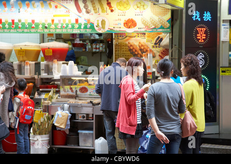 Il gruppo di donne cinesi strada mangiando cibi e bevande da una strada negozio a Causeway Bay Hong kong RAS di Hong kong cina asia Foto Stock