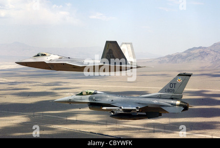 NELLIS AIR FORCE BASE, Nev. -- un F/A-22 Raptor volato dal maggiore David Thole vola la formazione delle dita su una missione di addestramento 23 giugno accanto a un F-16 combattendo Falcon volato dal maggiore Alex Grynkewich. Major Thole è assegnato al 422esimo Squadron di prova e valutazione, e Major Grynkewich è dal 53esimo Gruppo di prova e valutazione. Foto Stock