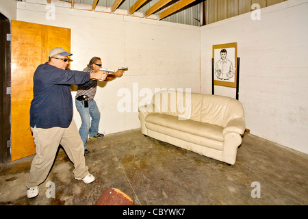 Sotto gli occhi di un istruttore, applicazione della legge pratica agenti di entrare o 'VIOLAZIONE' una stanza con le armi. Foto Stock