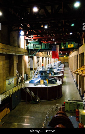 Turbine della centrale idroelettrica di Hoover Dam Nevada | HOOVER DAM, Nevada — Le cime di otto turbine massicce dominano il pavimento della centrale sul lato del Nevada del Hoover Dam, con altre nove turbine situate sul lato dell'Arizona. Queste turbine generano elettricità dall'acqua che scorre attraverso la diga e nel fiume Colorado sottostante. Le turbine sono alte circa 30 piedi dal livello del suolo, con altri 40 piedi che si estendono sotto questo pavimento. La sala della centrale si estende per circa 650 piedi di lunghezza. Una gru enorme in grado di sollevare 300 tonnellate è visibile sopra la testa, utilizzata per la manutenzione e e Foto Stock