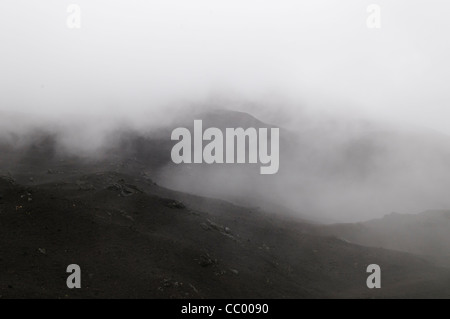 VULCANO PACAYA, Guatemala, mentre le nuvole avvolgono la cima del vulcano Pacaya, il vapore sale dal terreno ancora caldo. Pacaya è un vulcano attivo che fa parte dell'arco vulcanico dell'America centrale. Costituisce una popolare destinazione turistica facilmente accessibile da Antigua e città del Guatemala. Situato all'interno del Parco Nazionale Pacaya, si erge a 2.552 metri (8.373 piedi). La sua ultima grande eruzione, che causò una notevole damange ai villaggi vicini e rimodellò la cima, fu nel maggio 2010. Quell'eruzione e la cenere vulcanica sparsa su gran parte della zona circostante, provocando chiusure scolastiche e emergenza Foto Stock