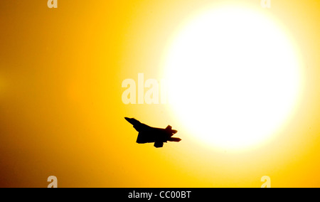 Un F22un Raptor fa passare da una impostazione lentamente Alaskan sole mentre pracing toccare e va a Elmendorf Air Force Base in Alaska sett. 17. Foto Stock