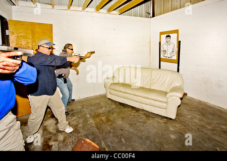 Sotto gli occhi di un istruttore, applicazione della legge pratica agenti di entrare o 'VIOLAZIONE' una stanza con le armi. Foto Stock