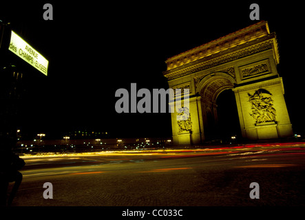 All'estremità occidentale del Champs-Élysées, il traffico notturno whizzes intorno all'Arc de Triomphe, uno dei più famosi monumenti di Parigi, Francia. Foto Stock