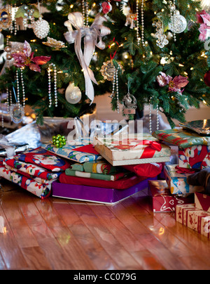 Albero di Natale decorato con argento e bianco nastri e ornamenti con regali impacchettati sotto l'albero Foto Stock