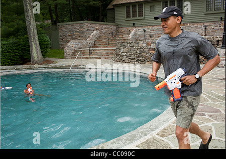 Il presidente Barack Obama corre attorno alla piscina durante una pistola ad acqua in lotta con sua figlia Sasha nel giorno del suo compleanno weekend a Camp David 11 giugno 2011 Thurmont, MD. Foto Stock
