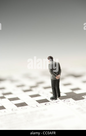 Una piccola figura di un uomo su un cruciverba Foto Stock