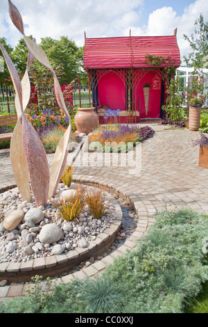 Red pavilion con patio pavimentato e scultura decorativa. Foto Stock