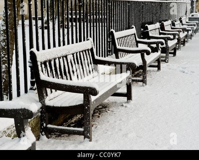 Panchine innevate all'interno del parco Foto Stock