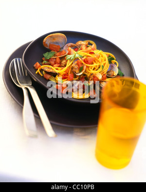 Lo zafferano - spaghetti con gusci di vongole e pomodori Foto Stock