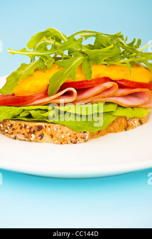 Aprire il panino con formaggio fuso e decorazione di insalata Foto Stock