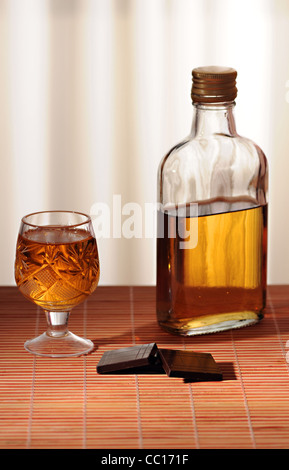 Cioccolato e una bottiglia di whiskey è sul tavolo Foto Stock